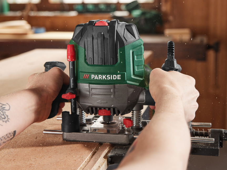 A person uses a Parkside router to work wood.