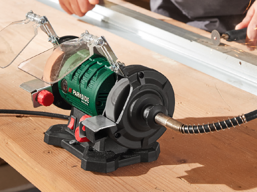 A Parkside bench grinder with a flexible shaft attachment on a wooden workbench.