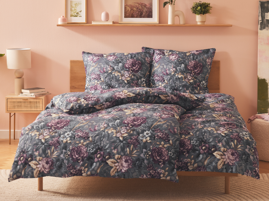 A dark gray floral duvet cover set with matching pillowcases sits on a bed.