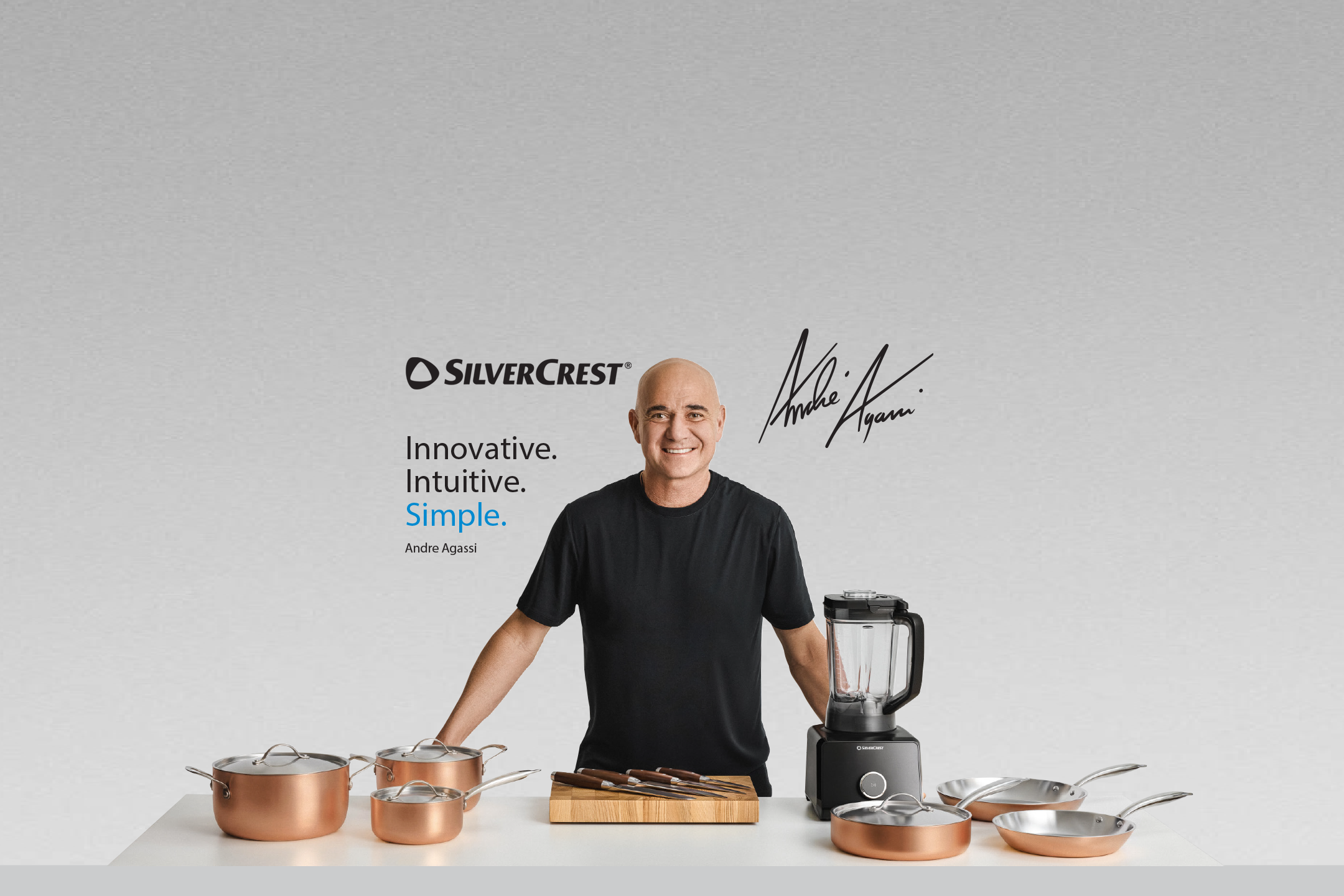 Silvercrest promotional banner featuring brand ambassador Andre Agassi alongside a selection of copper cookware, a blender, and knives, with the slogan: Innovative. Intuitive. Simple.