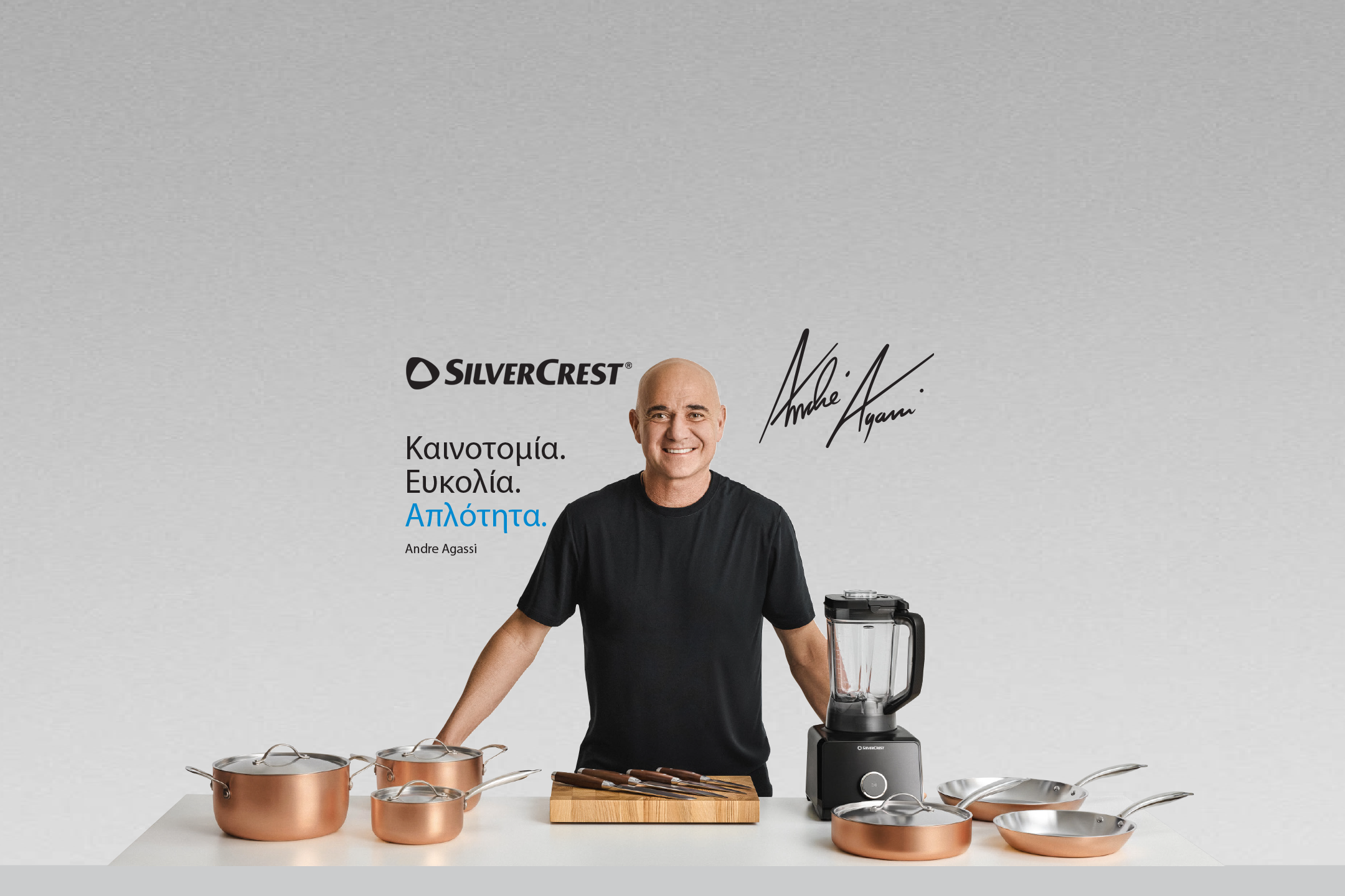 Διαφημιστικό banner της Silvercrest με τον Andre Agassi και το σύνθημα 'Καινοτομία. Ευκολία. Απλότητα.' δίπλα σε μια σειρά από χάλκινα μαγειρικά σκεύη και ένα μπλέντερ.