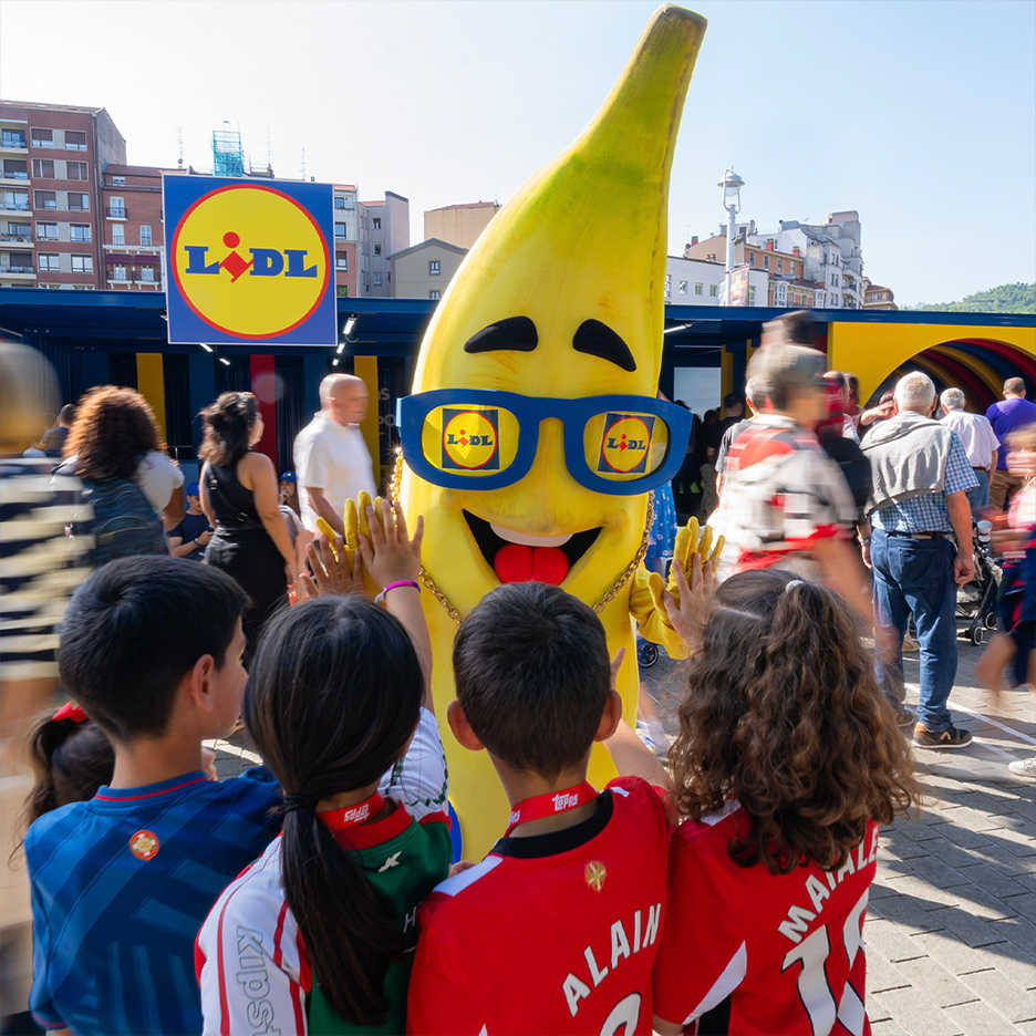 Djeca pozdravljaju maskotu u obliku banane sa sunčanim naočalama.