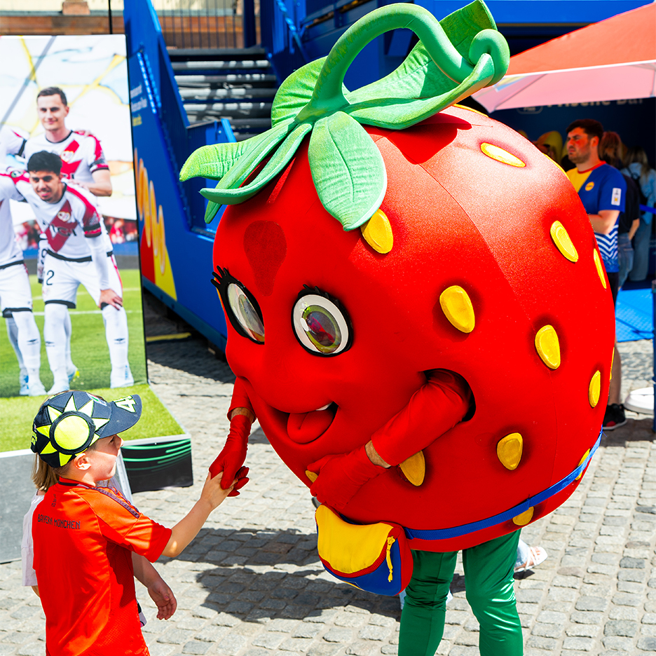 Dijete se rukuje s Lidl maskotom jagode