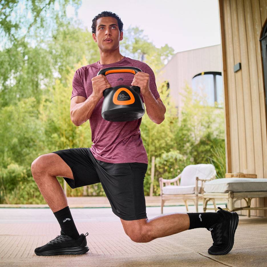 Άνδρας κάνει προβολές με kettlebell 10 κιλών σε εξωτερικό χώρο.