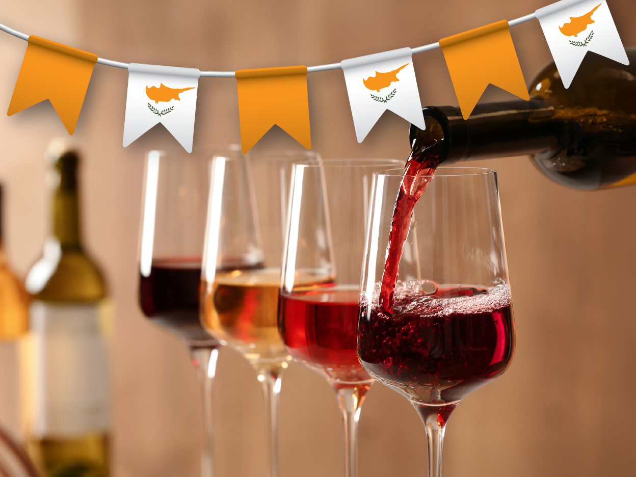Cypriot wine is poured into glasses against a backdrop of Cypriot flags.