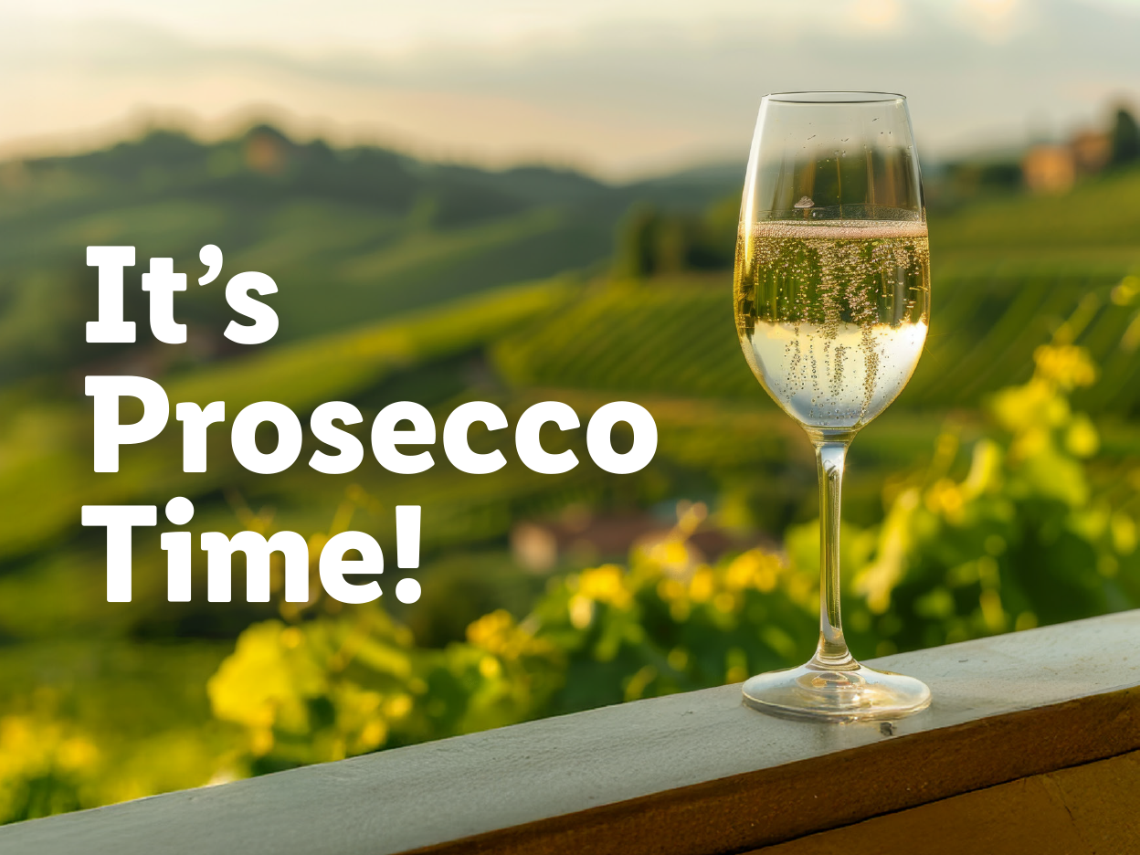 A glass of sparkling wine on a railing overlooking a vineyard with text 'It's Prosecco Time!'