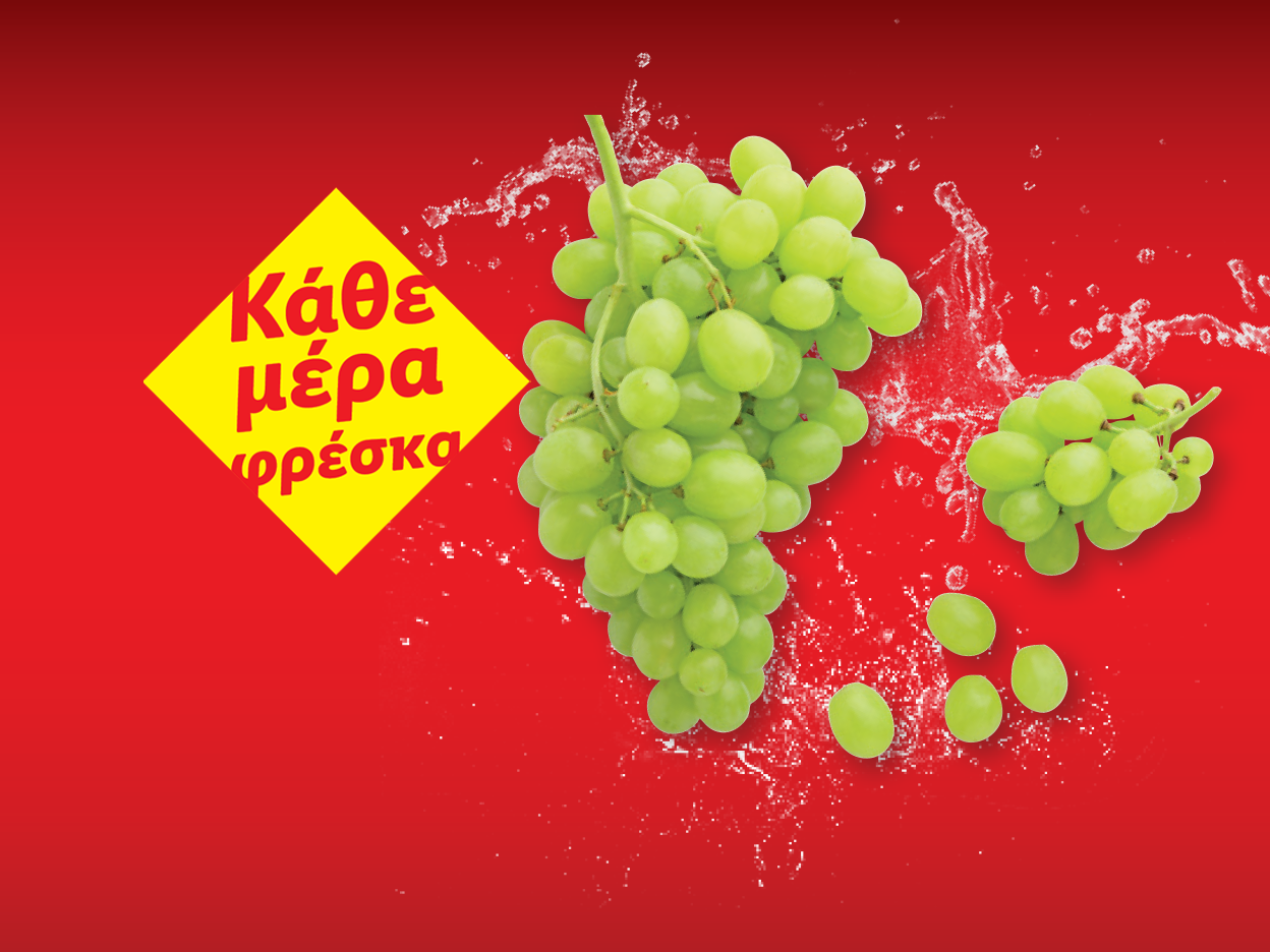 Φρέσκα πράσινα σταφύλια με πιτσιλιές νερού σε κόκκινο φόντο.