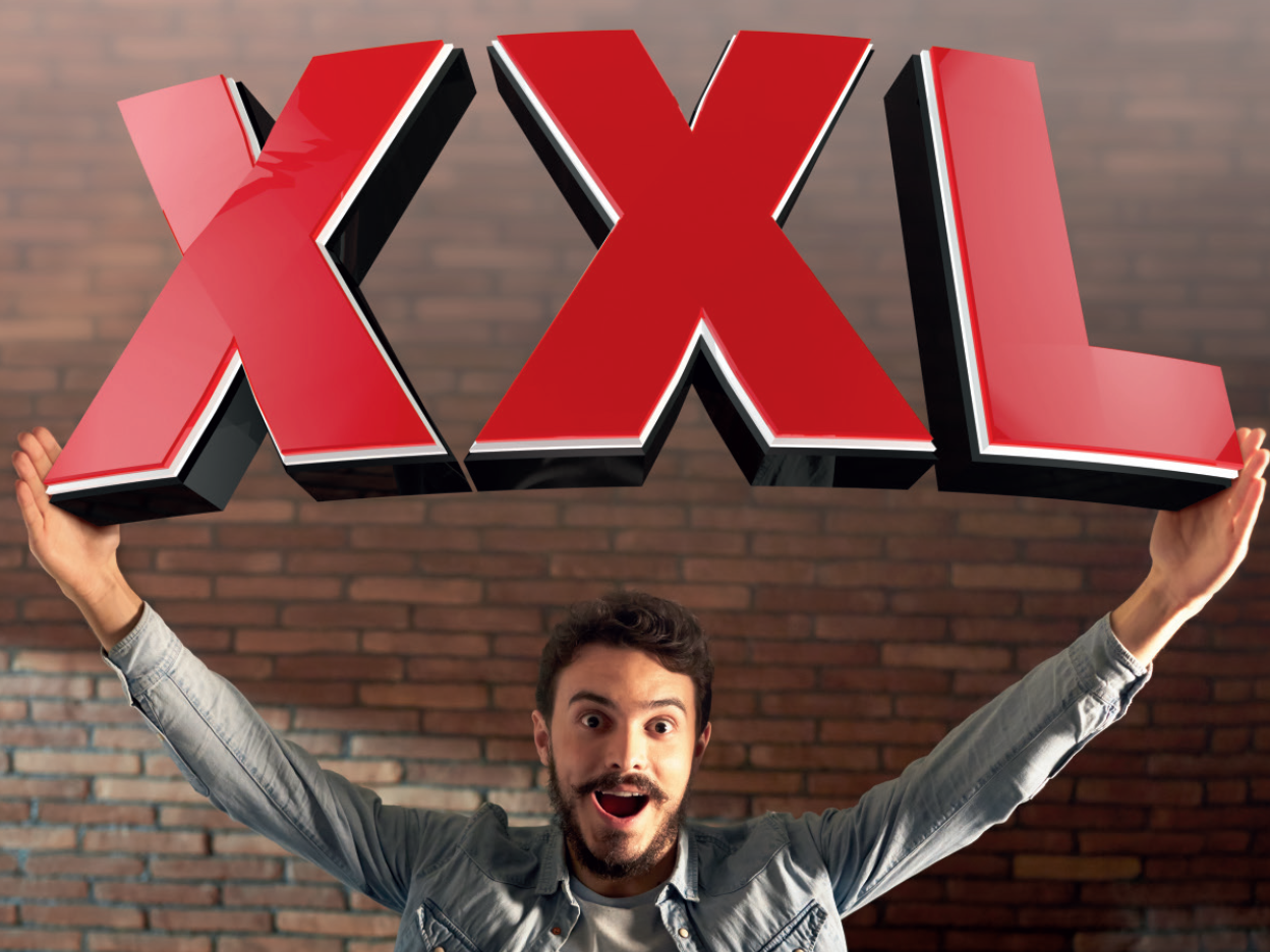 Man holds up large XXL letters.