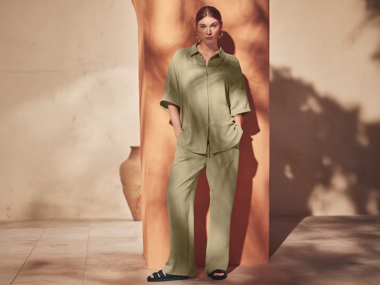 A woman models a stylish, light-colored jumpsuit with three-quarter sleeves.