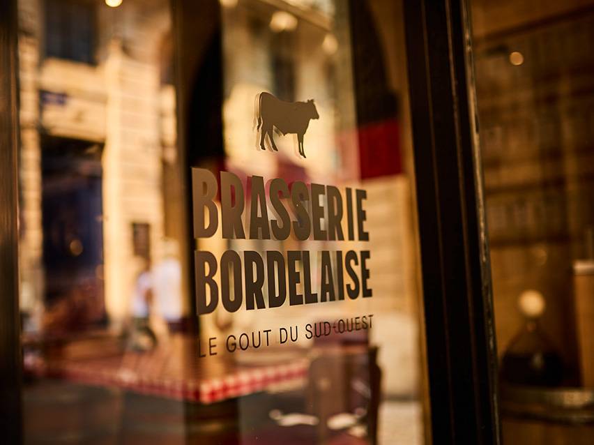 Brasserie Bordelaise sign with a cow silhouette and the text 'Le Goût du Sud-Ouest'.