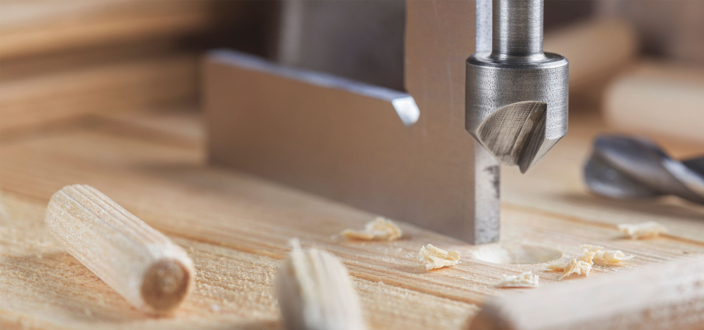 Wooden dowels, drill bit, and wood during construction.