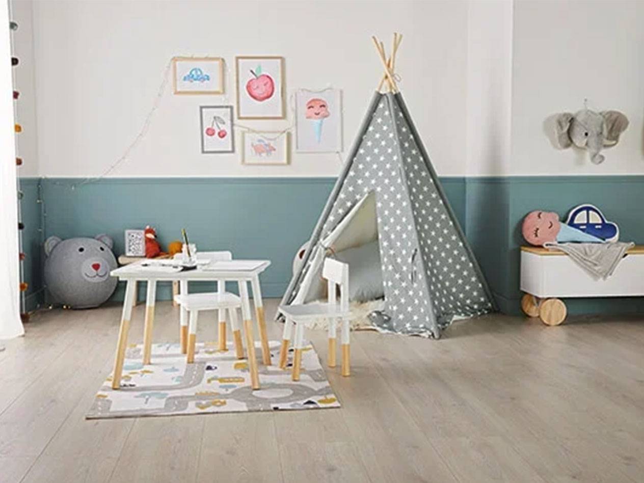 Children's room with a teepee tent, table and chairs, toy chest, and pictures on the wall.