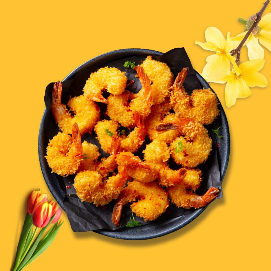 Τραγανές τηγανητές γαρίδες σε μαύρο πιάτο, με κίτρινα λουλούδια και κόκκινες τουλίπες.
