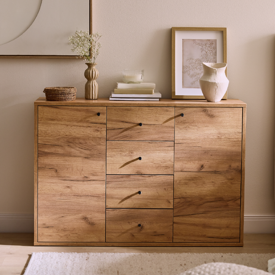Wooden sideboard with decorative vases, framed art, and a woven basket.