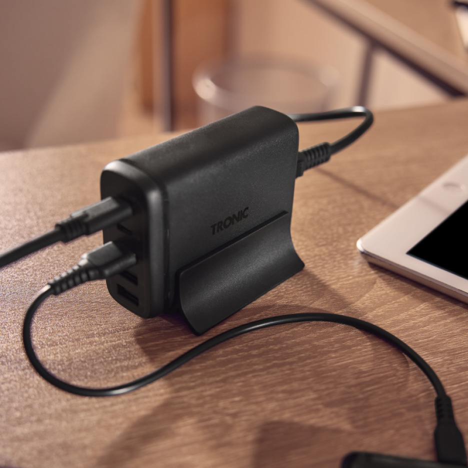 Επιτραπέζιος φορτιστής USB πολλαπλών θυρών με συνδεδεμένα καλώδια σε ξύλινο τραπέζι.