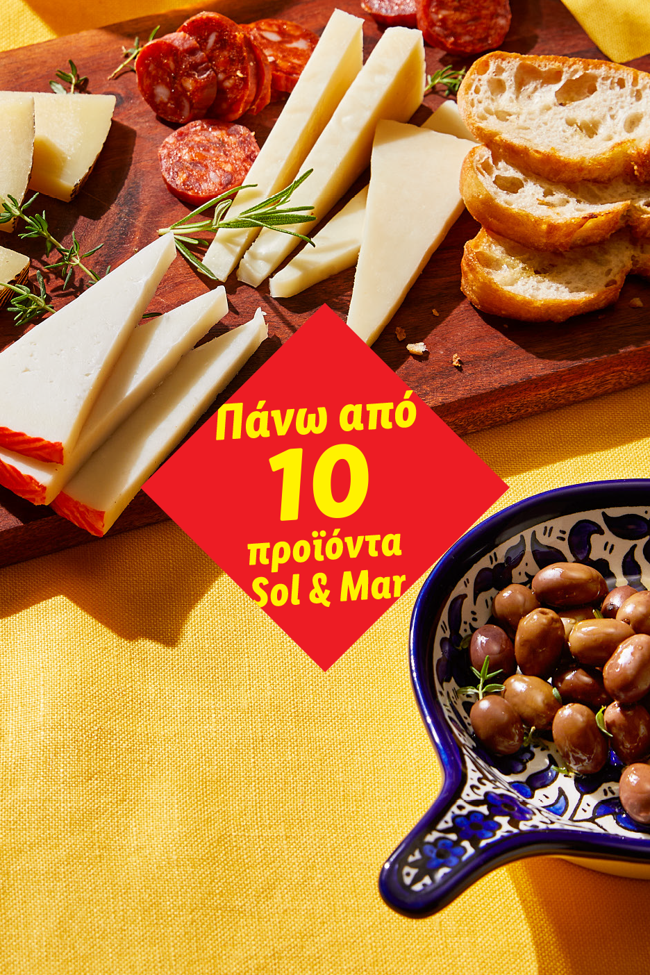 Πλατό τυριών και αλλαντικών με ψωμί και ελιές, με κόκκινο πανό που γράφει κείμενο.