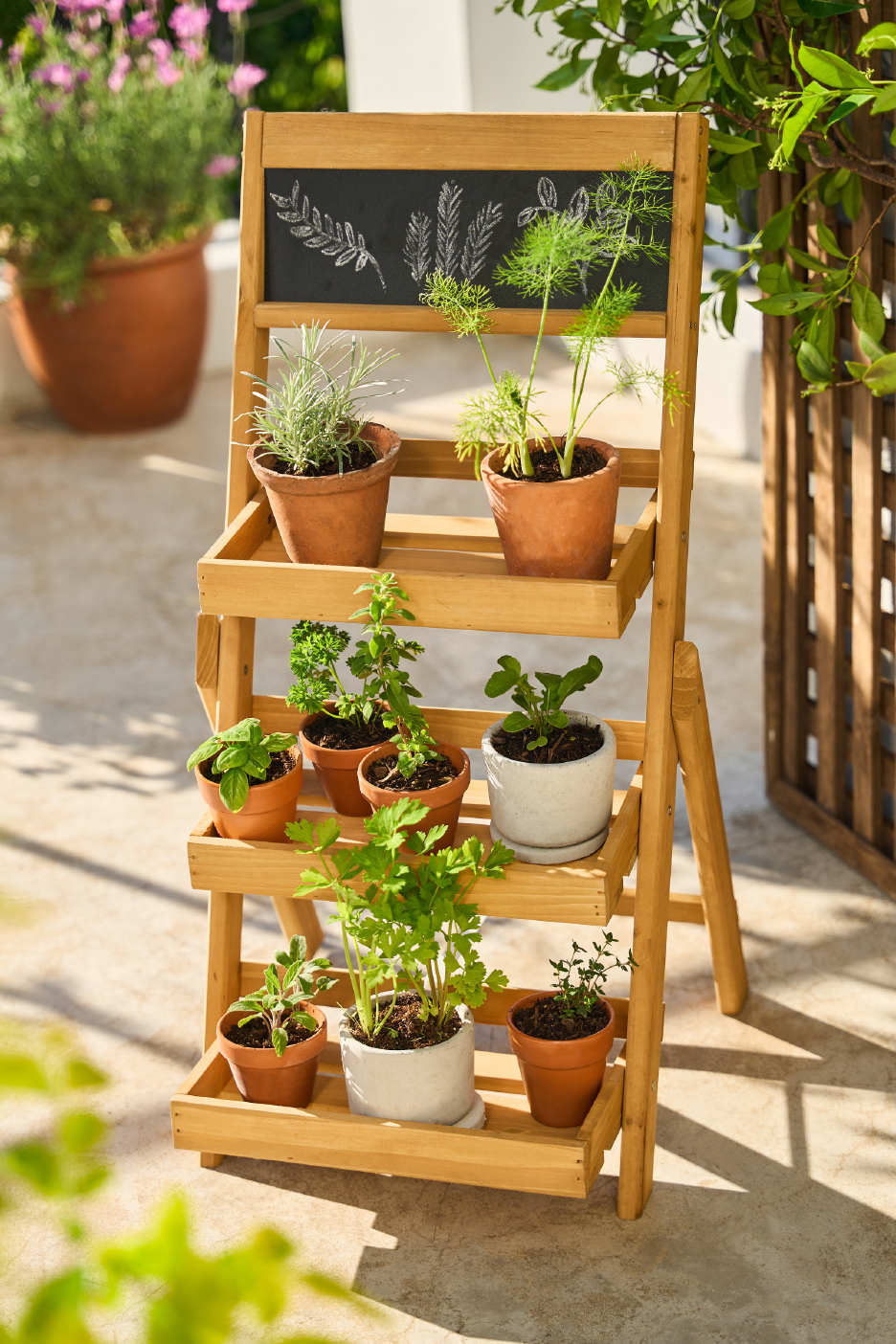 Wooden herb garden stand with various potted herbs on a sunny patio.