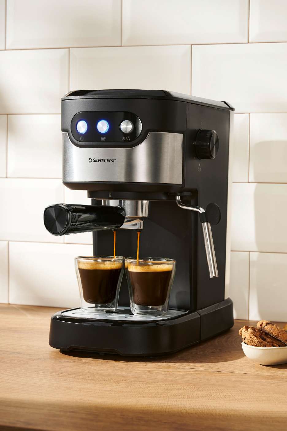 Μηχανή εσπρέσο που παρασκευάζει καφέ σε δύο γυάλινα φλιτζάνια σε ξύλινο πάγκο