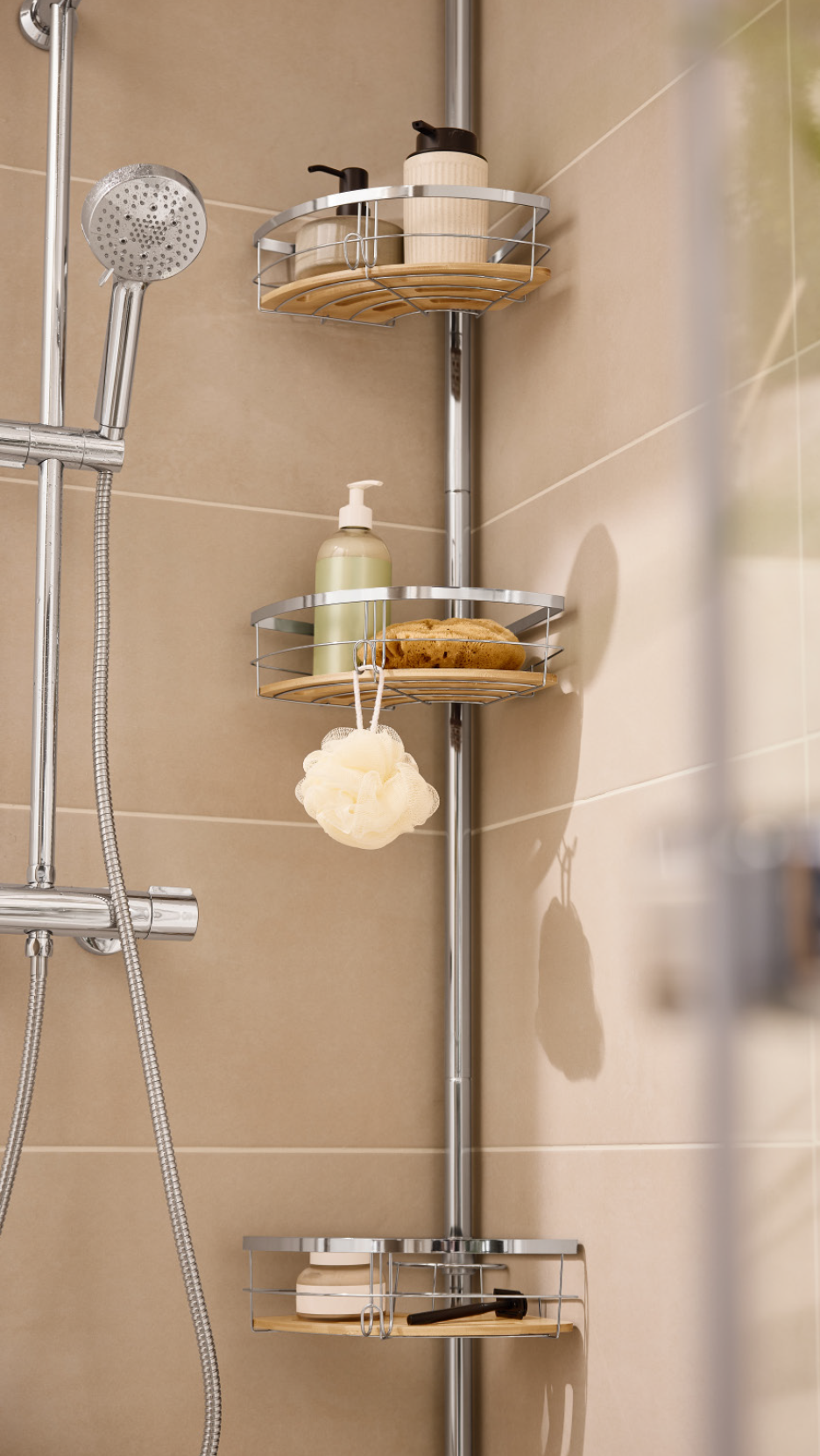 Shower caddy with shower gel, shampoo, and sponges in a tiled shower.