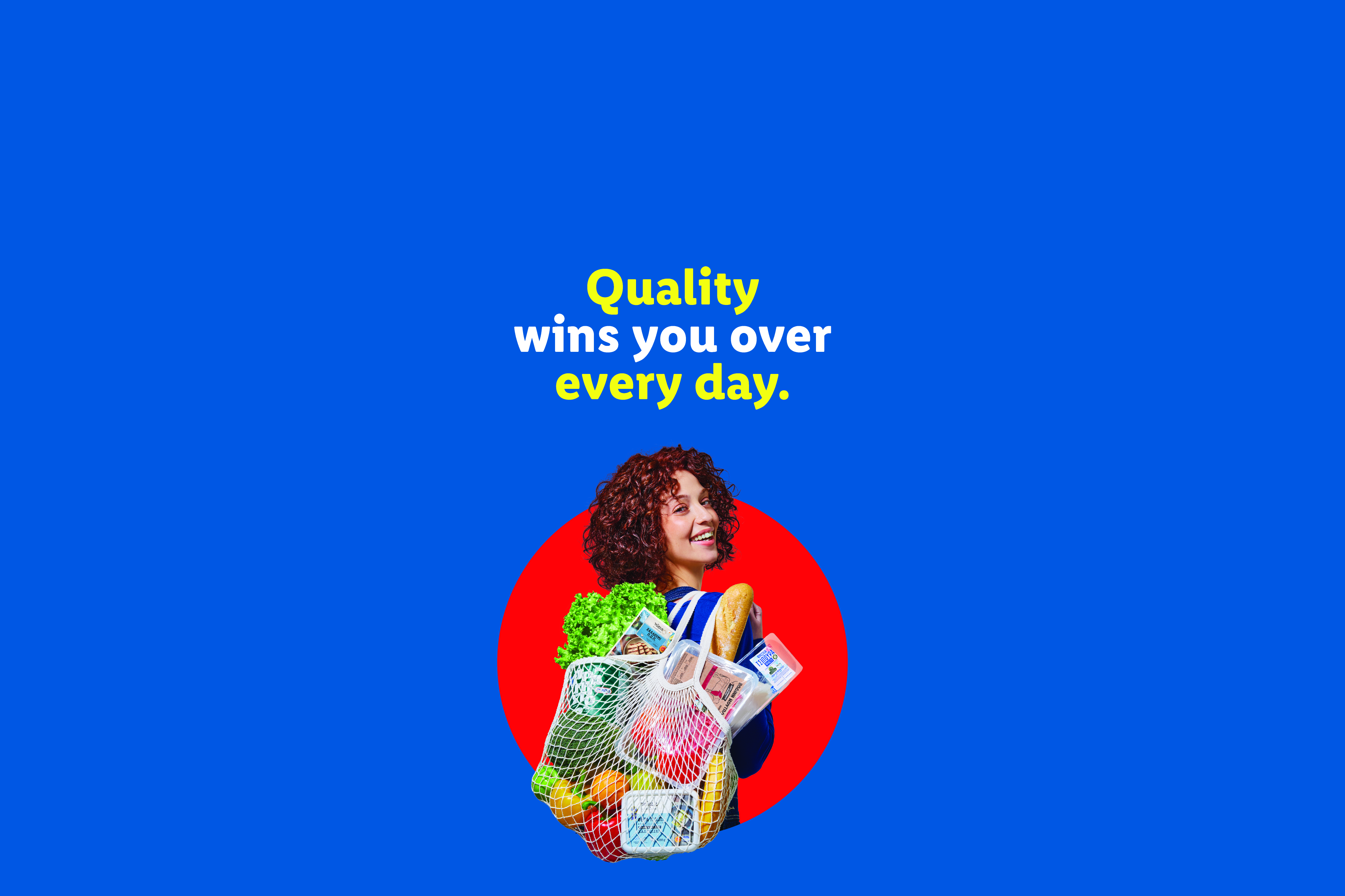 Woman with curly hair holding a reusable bag full of groceries, text: Quality wins you over every day.