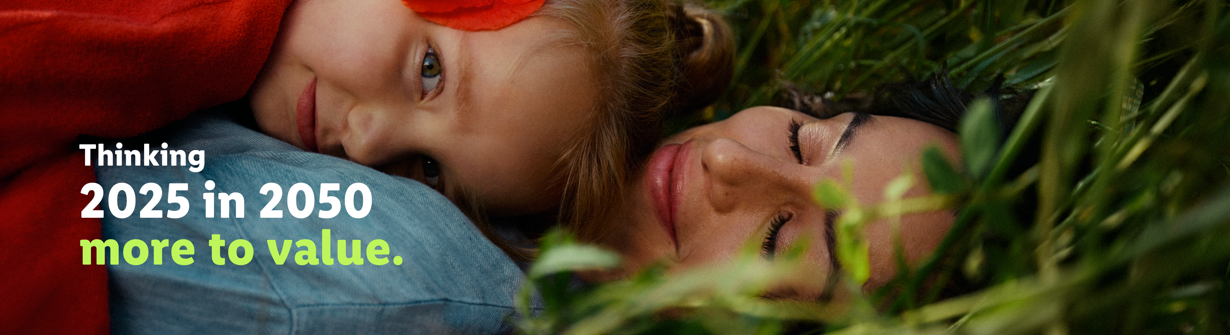 A woman and child lie in grass, with text: 'Thinking 2025 in 2050 more to value.'