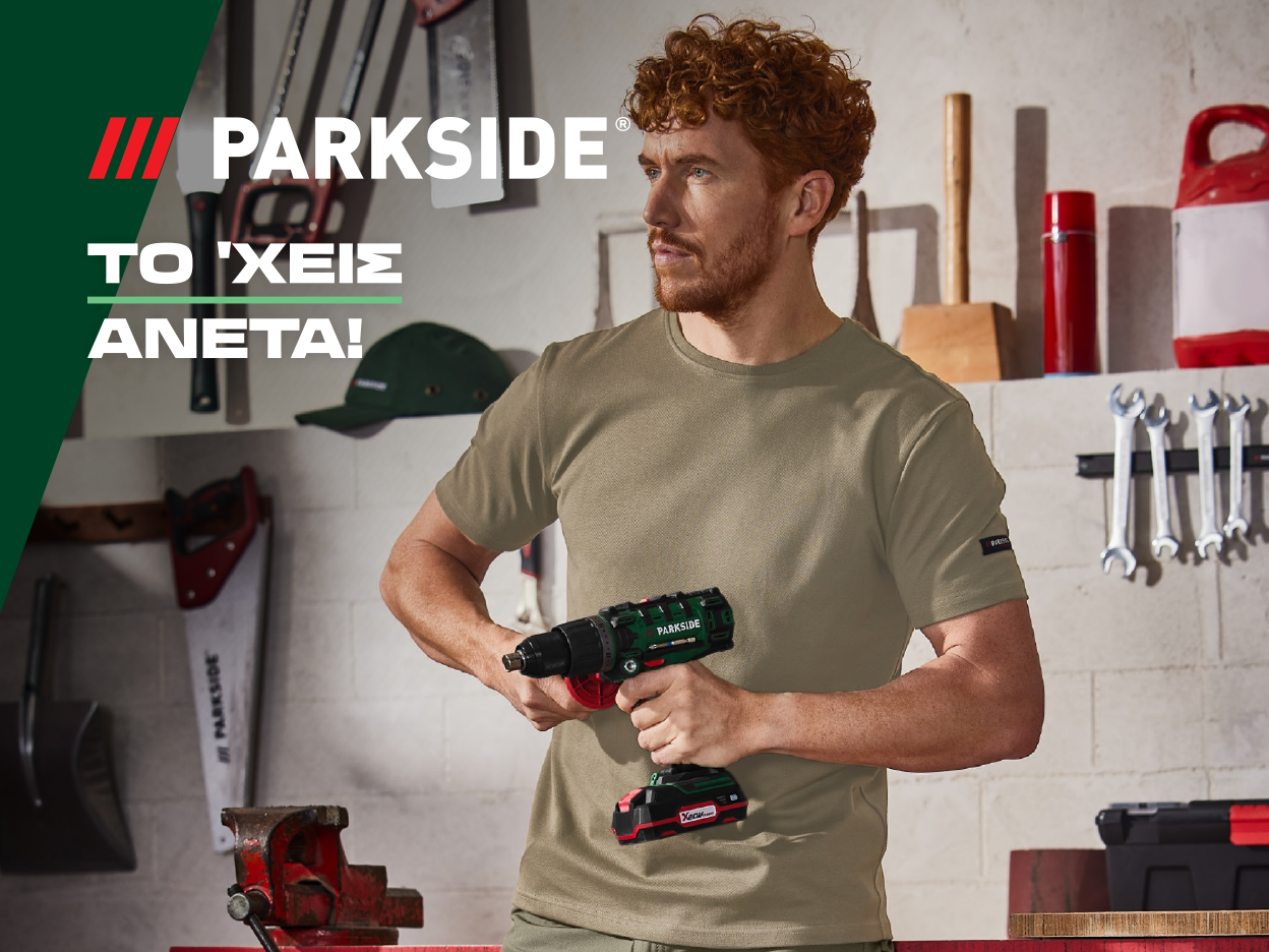 Άντρας με μπλούζα Parkside κρατάει ένα τρυπάνι Parkside σε εργαστήριο.