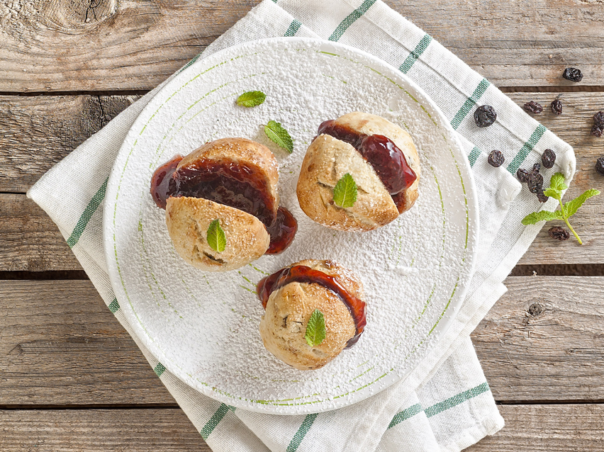 Muffins with jam on a white plate.