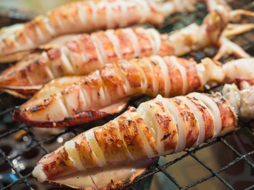 Ψητά καλαμάρια σε σχάρα μπάρμπεκιου, χαραγμένα και ελαφρώς απανθρακωμένα.