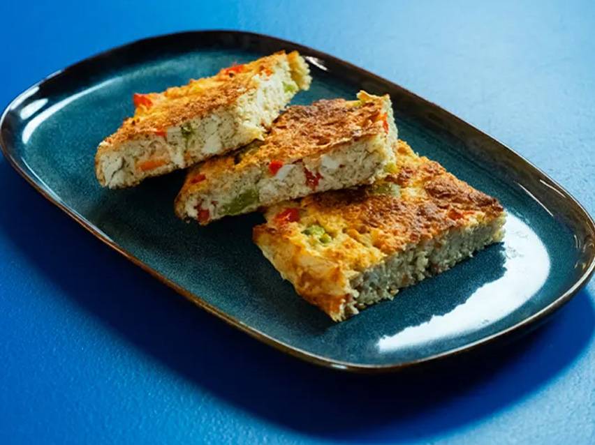 Three slices of vegetable frittata on a blue plate.