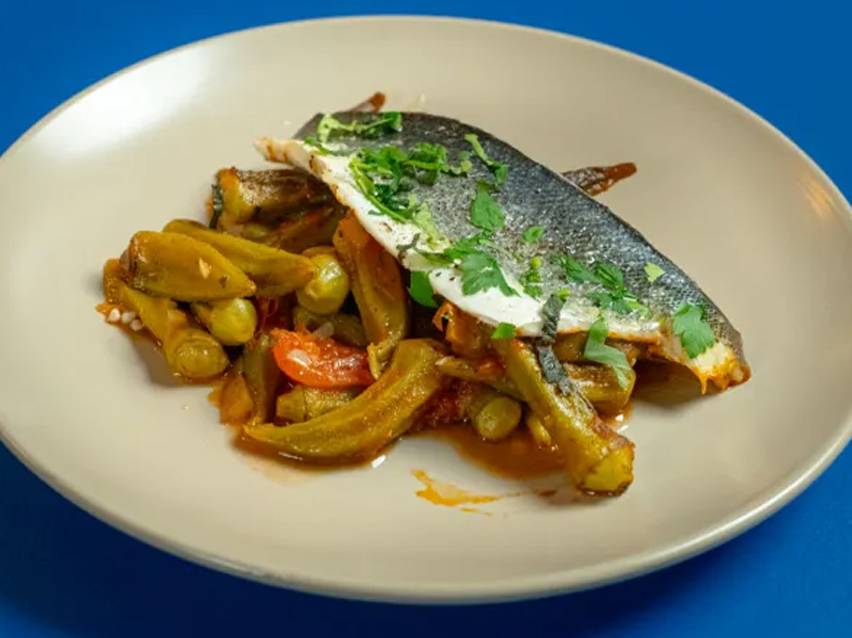 Μαγειρεμένο φιλέτο ψαριού με μπάμιες και ντομάτες σε πιάτο.