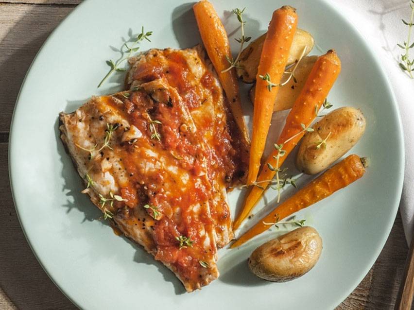 Fish fillets in sauce, roasted carrots and potatoes.