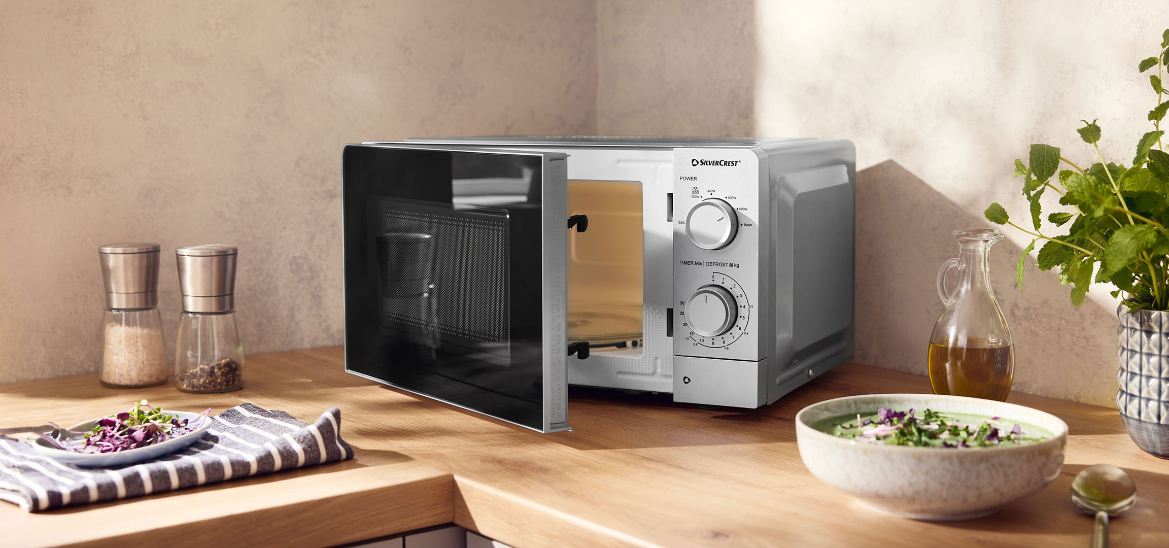 AI generated image: Microwave oven with an open door on a wooden counter, with spices and bowls.