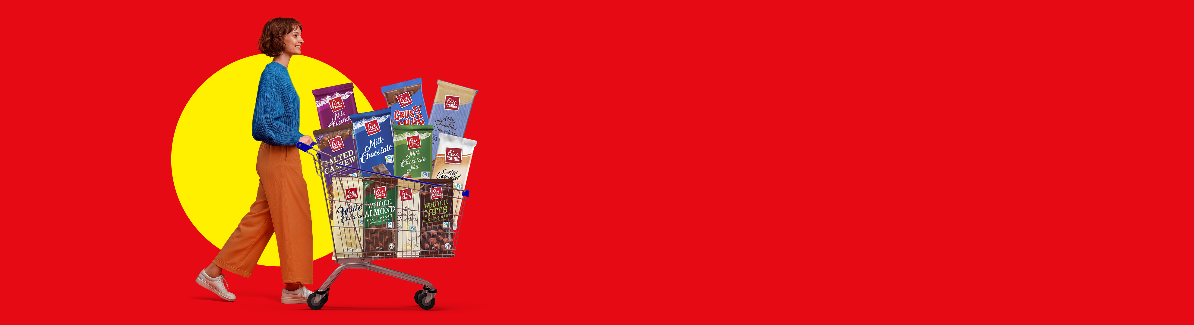 Woman pushing a shopping cart filled with various chocolate bars, including milk, white, and nut chocolates.