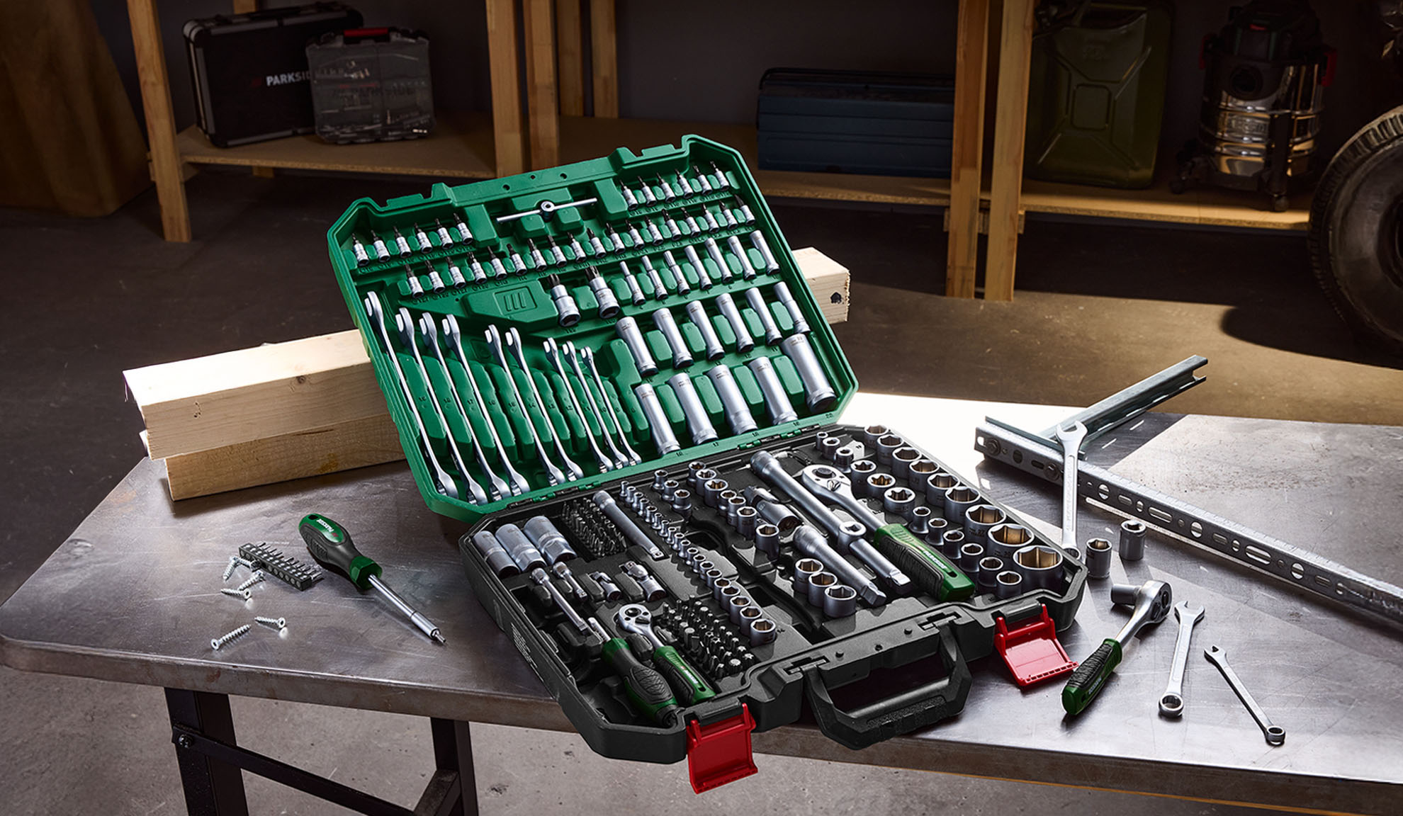 PARKSIDE tool set with wrenches, sockets, and screwdrivers on a metal table in a workshop.