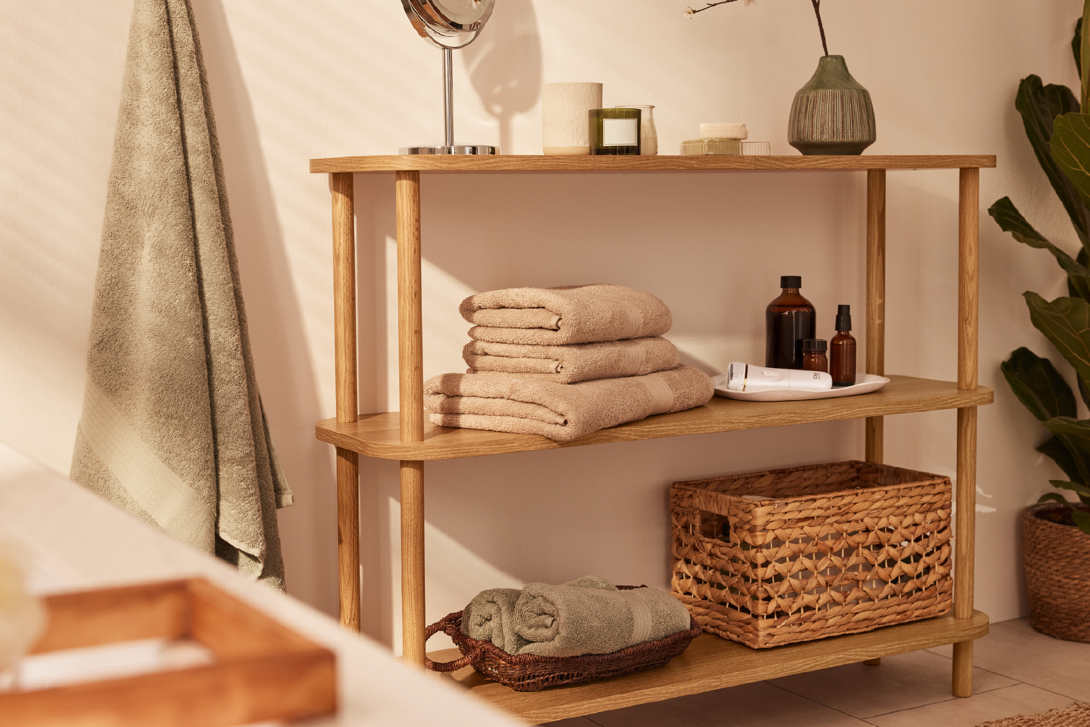 Bathroom shelf with folded towels, toiletries, and a woven basket.