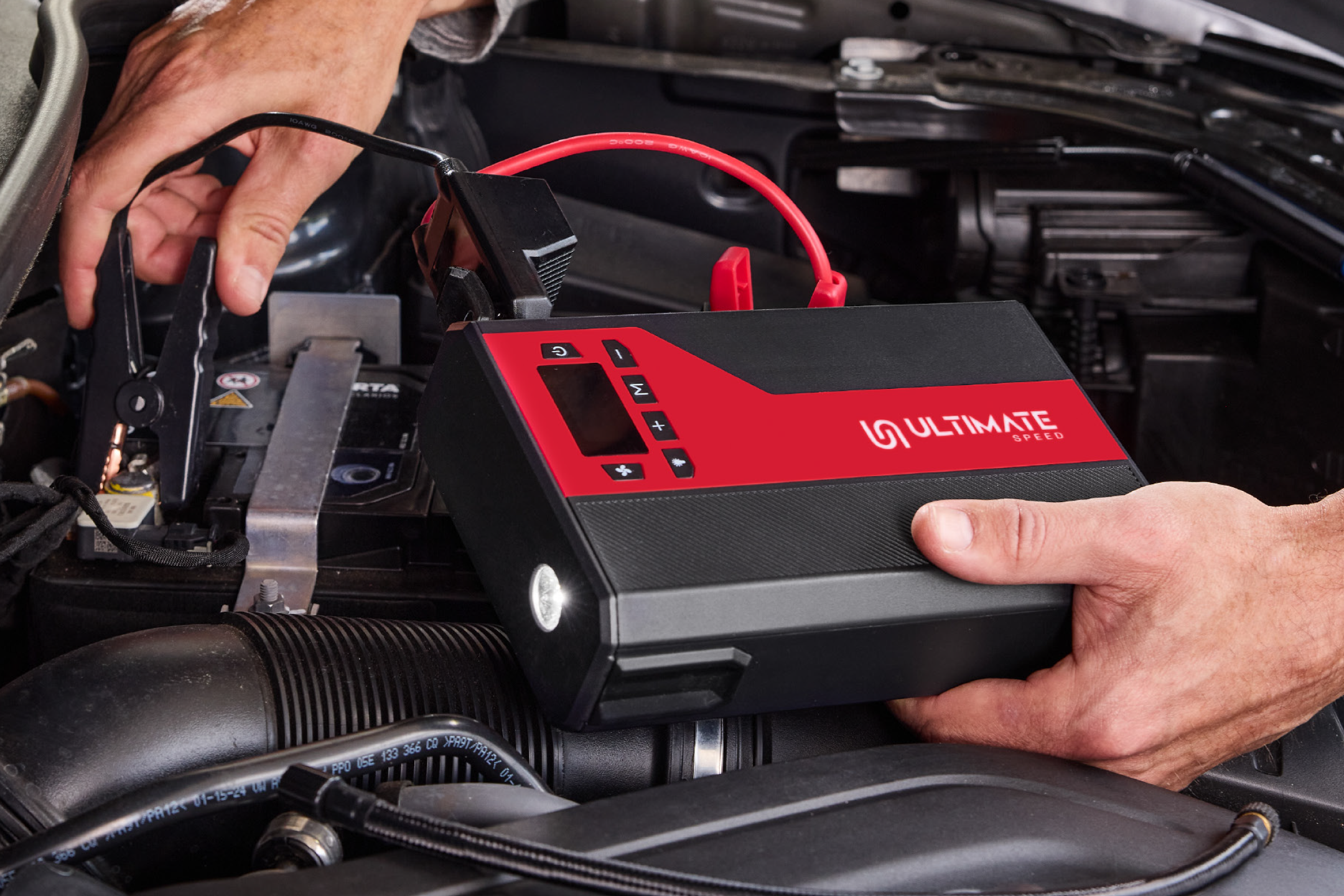 ULTIMATE SPEED jump starter connected to a car battery.