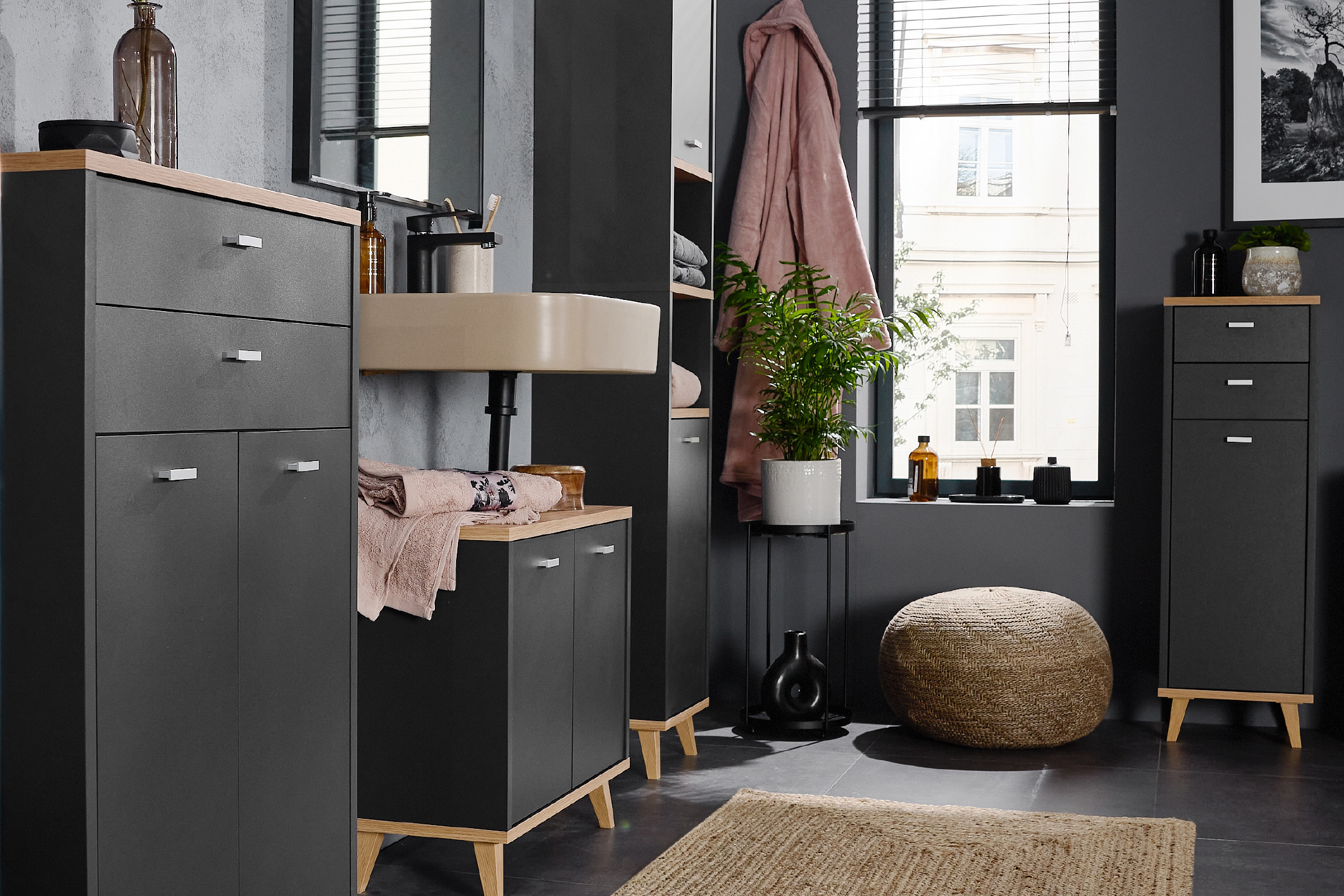 Modern dark grey bathroom furniture set with wooden accents and a light beige sink.
