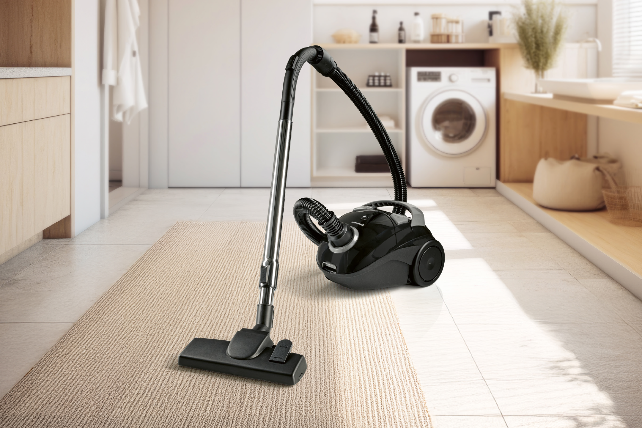 Ηλεκτρική σκούπα κάνιστρου σε χαλί σε ένα μοντέρνο πλυσταριό με πλυντήριο ρούχων.
