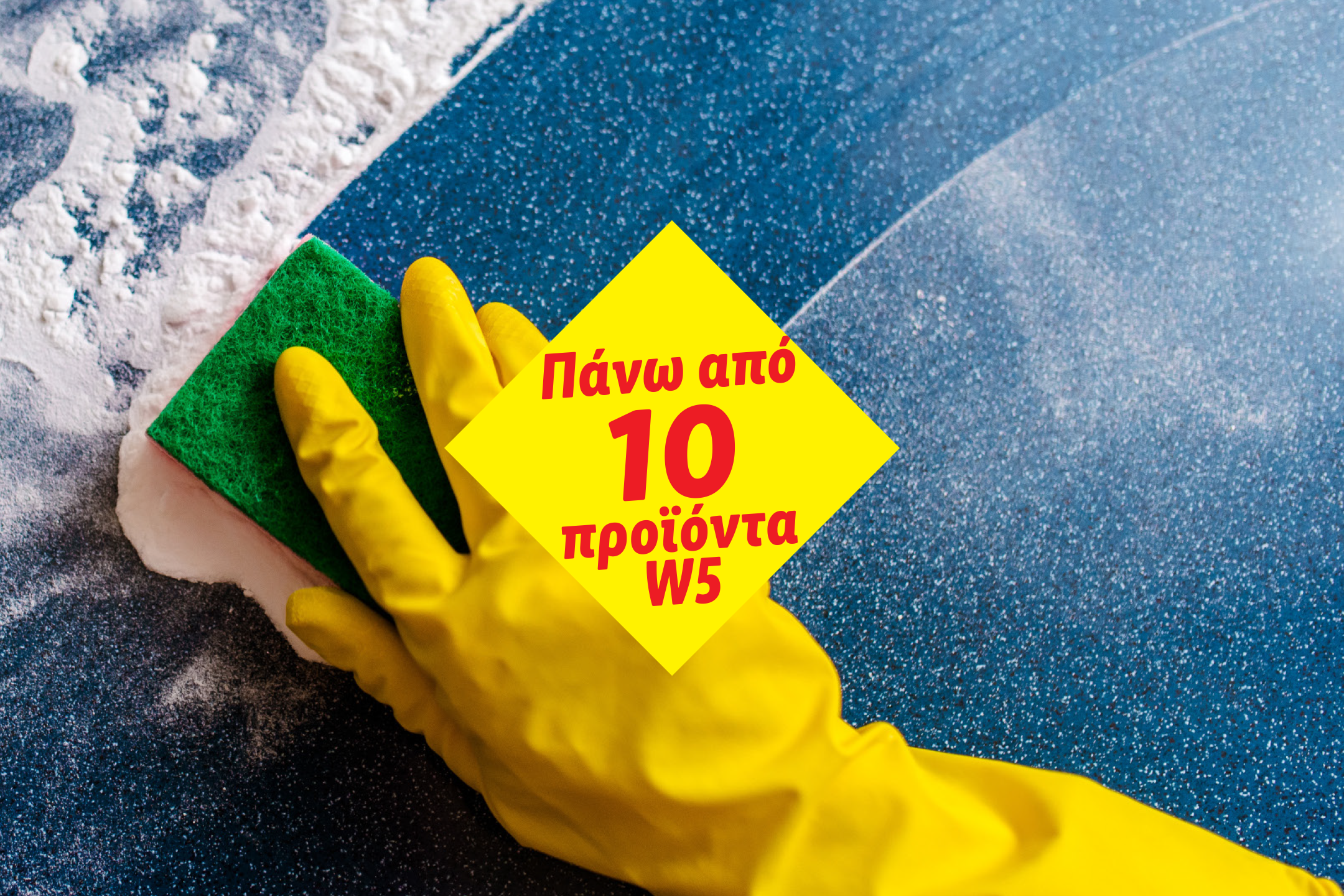 Χέρι με κίτρινο γάντι τρίβει μπλε επιφάνεια με πράσινο σφουγγάρι και λευκό αφρό.