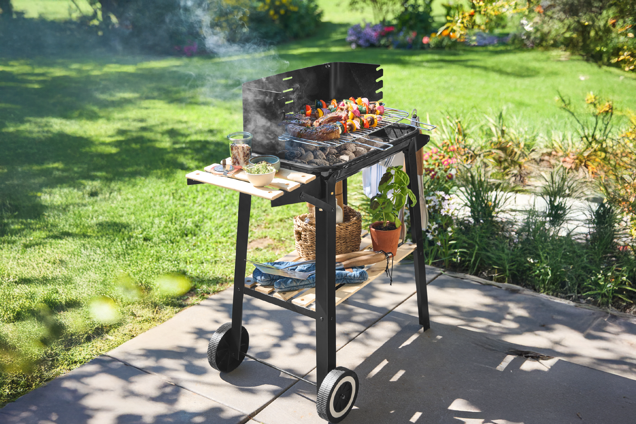 Ψησταριά μπάρμπεκιου με κρέας και σουβλάκια λαχανικών να ψήνονται, σε έναν ηλιόλουστο κήπο.