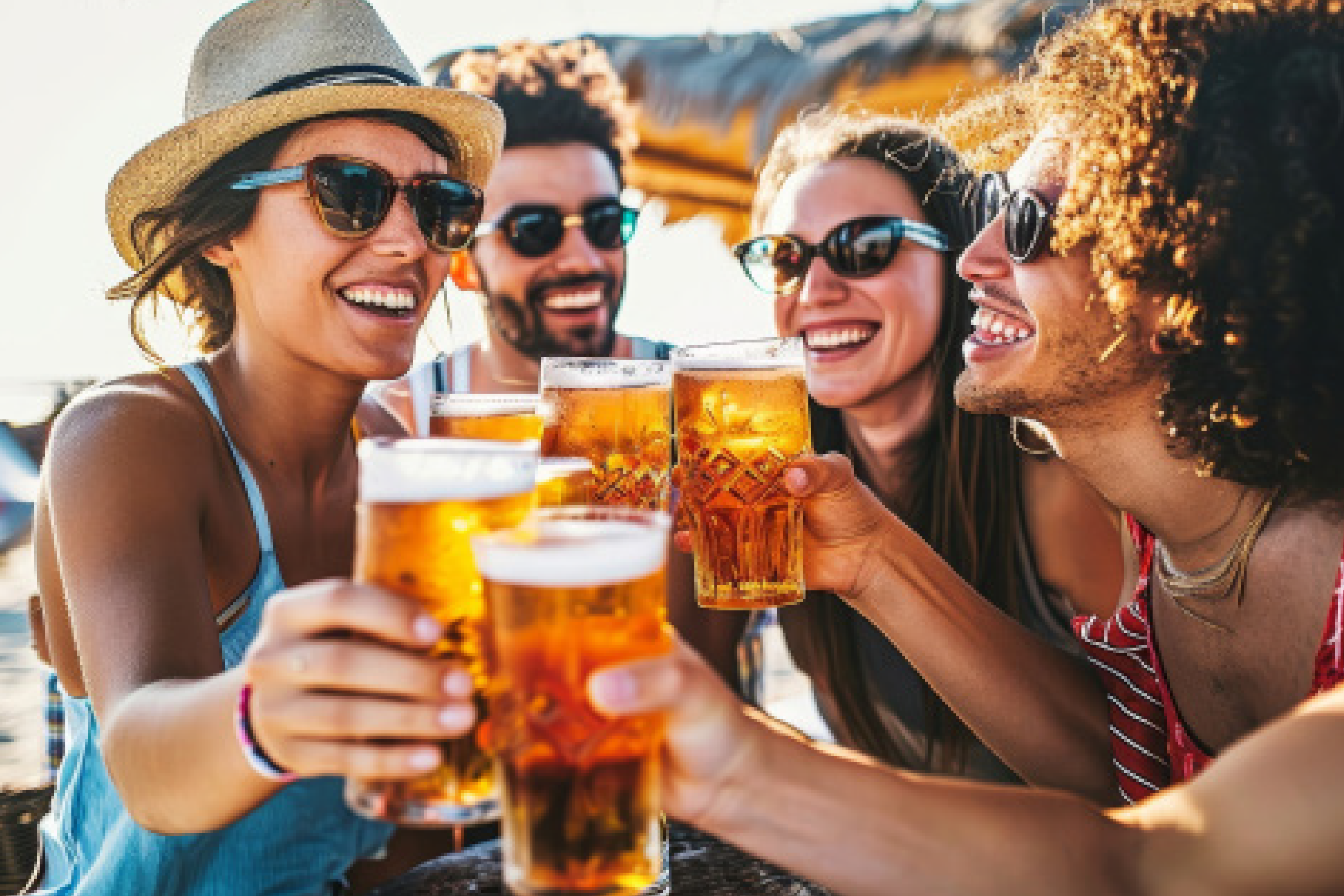 Friends toasting with beer glasses, enjoying a sunny outdoor gathering.