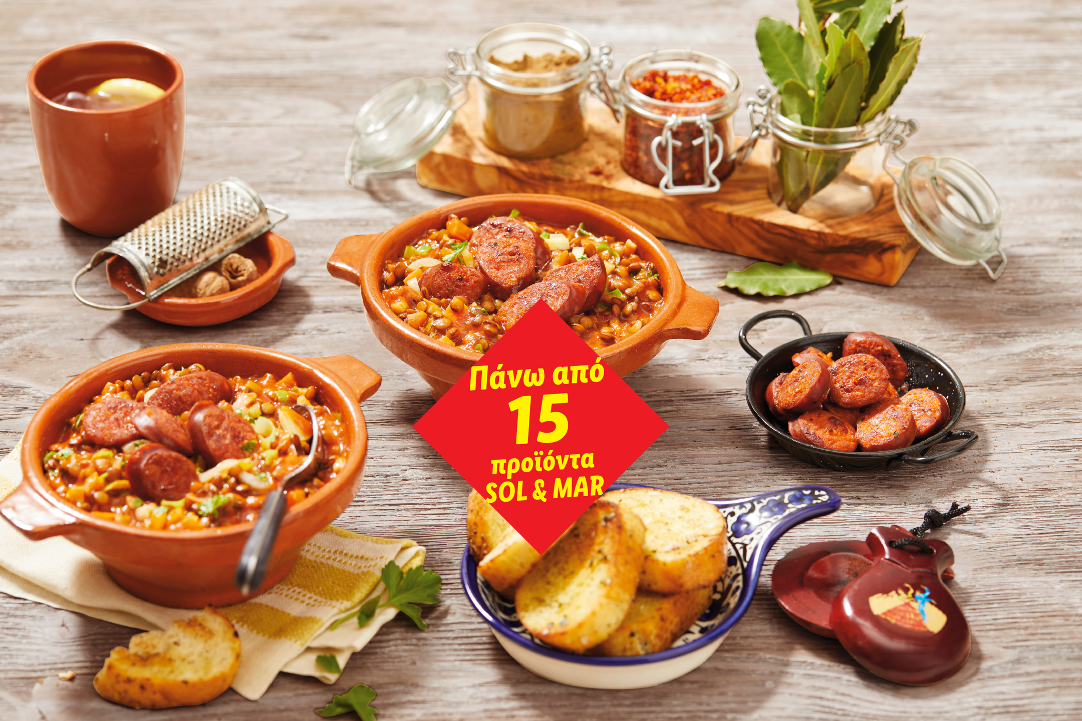 Δύο πήλινα μπολ με στιφάδο chorizo και φακές, με μπαχαρικά, ψωμί και καστανιέτες.