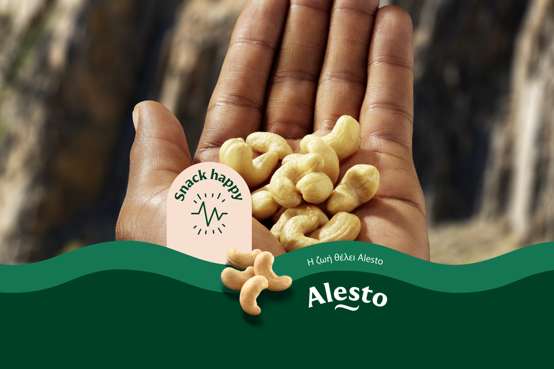 Hand holding cashews, with a 'snack happy' logo and green wavy design.