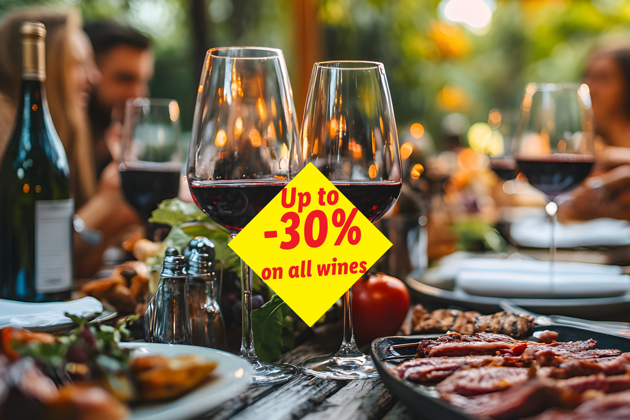 Red wine glasses on a table with food, advertising 'Up to -30% on all wines'