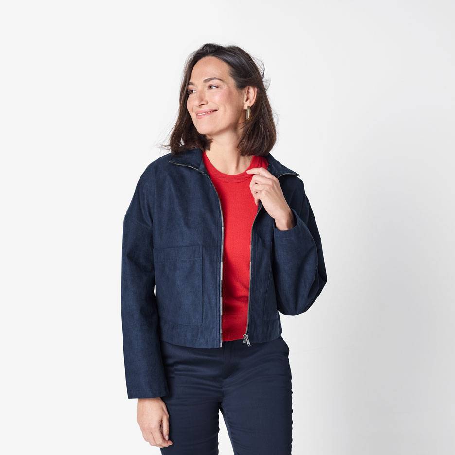 Woman in a dark blue bomber jacket and a red sweater