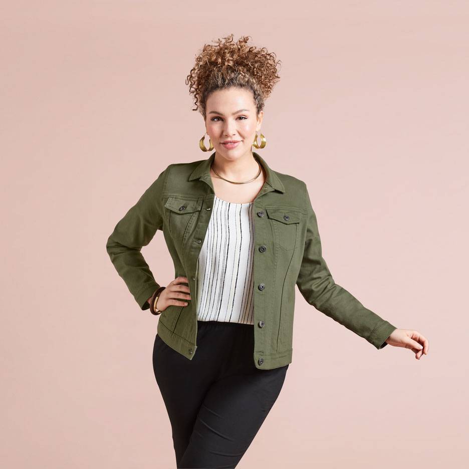 Woman in an olive green jacket, striped top, and black pants.